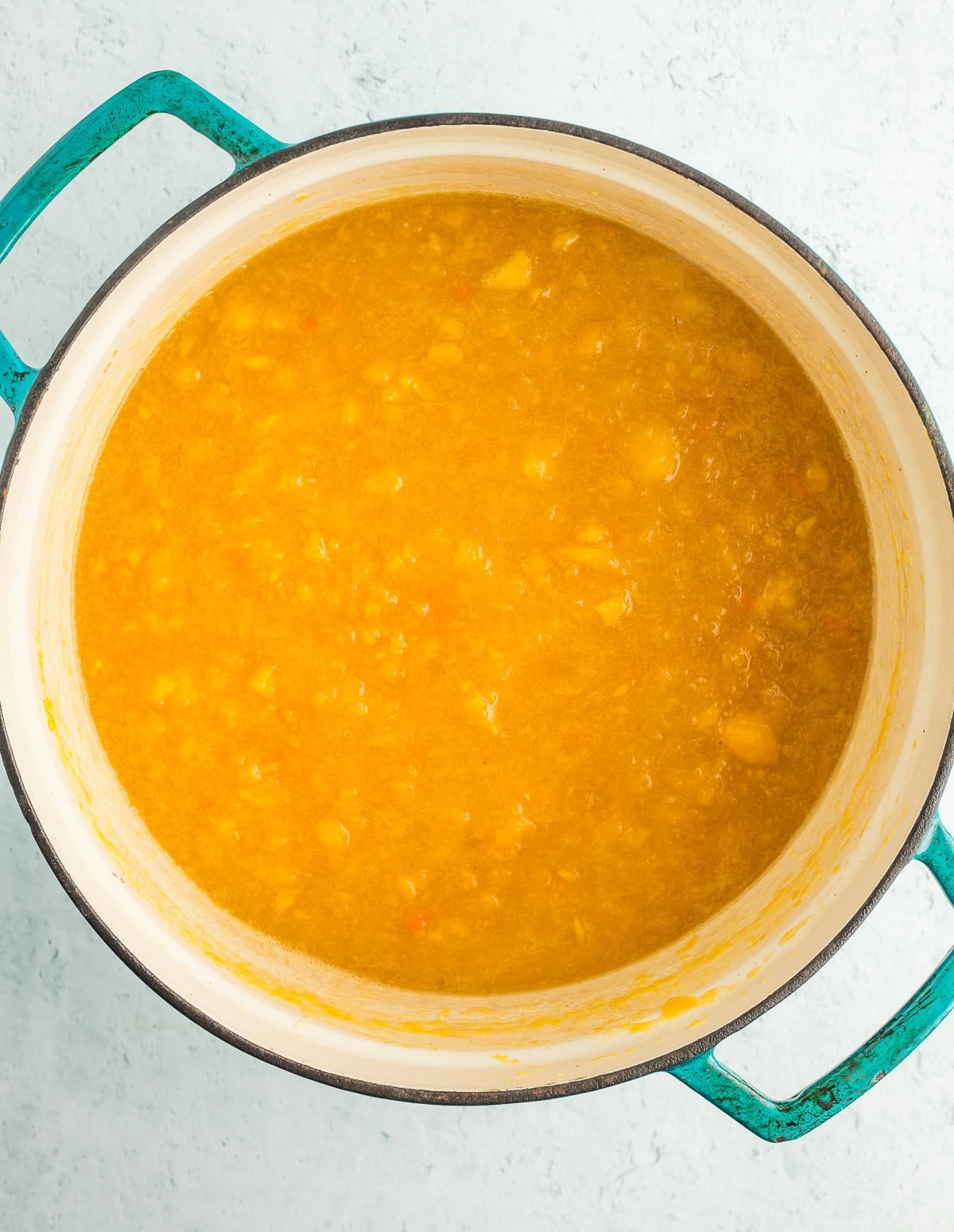 blended fruit in a teal dutch oven.