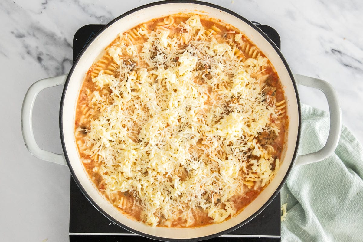 unbaked casserole topped with mozzarella in a white skillet.