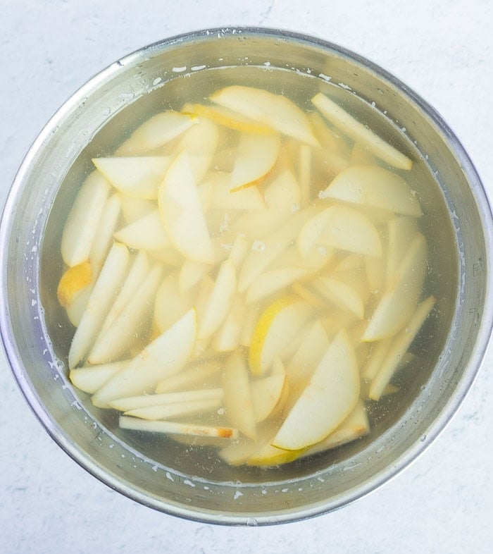 sliced fruit in a bowl of water.