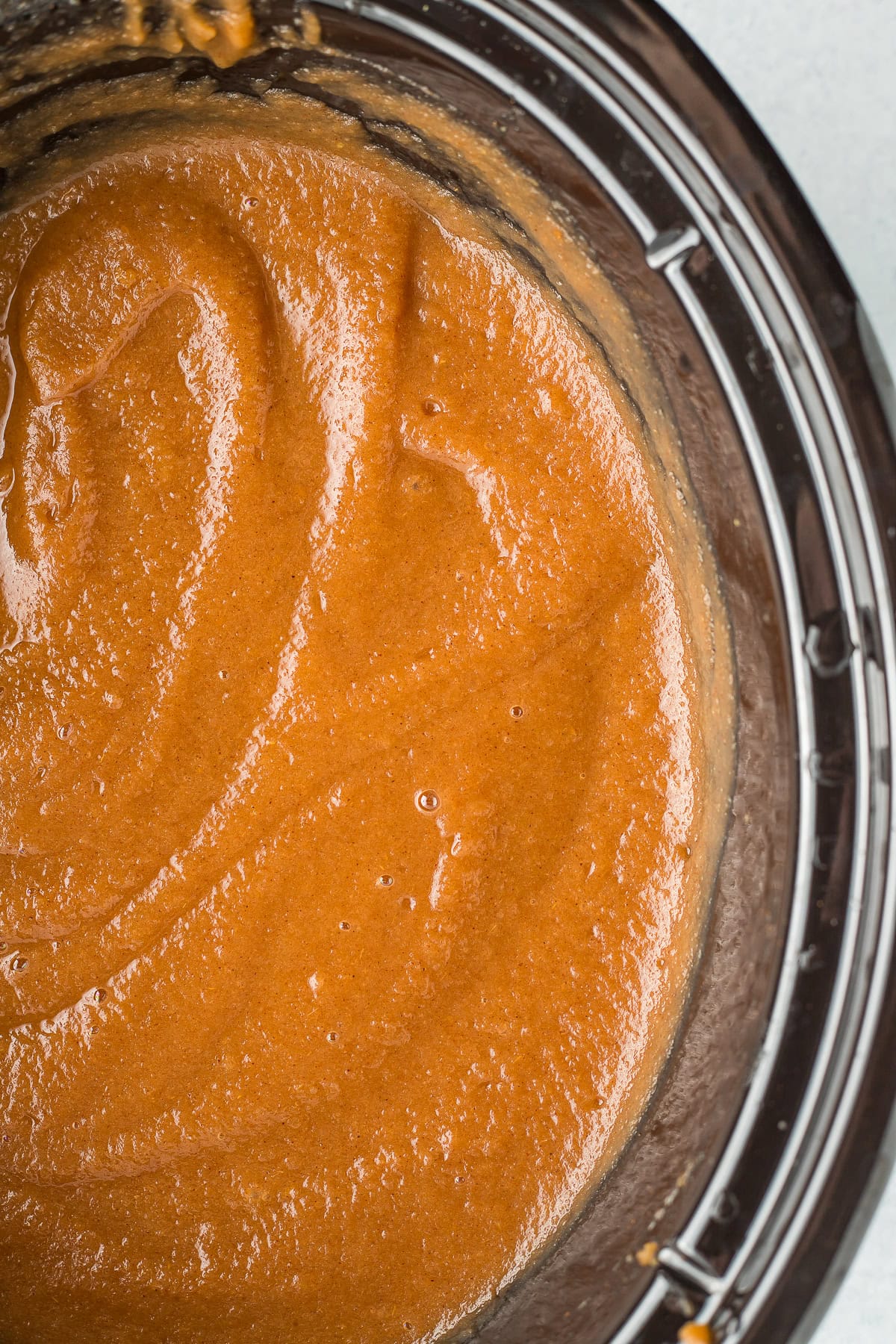 an up close photo of apple butter in a crockpot.