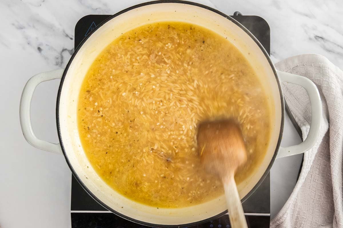 pasta and broth in a white skillet.