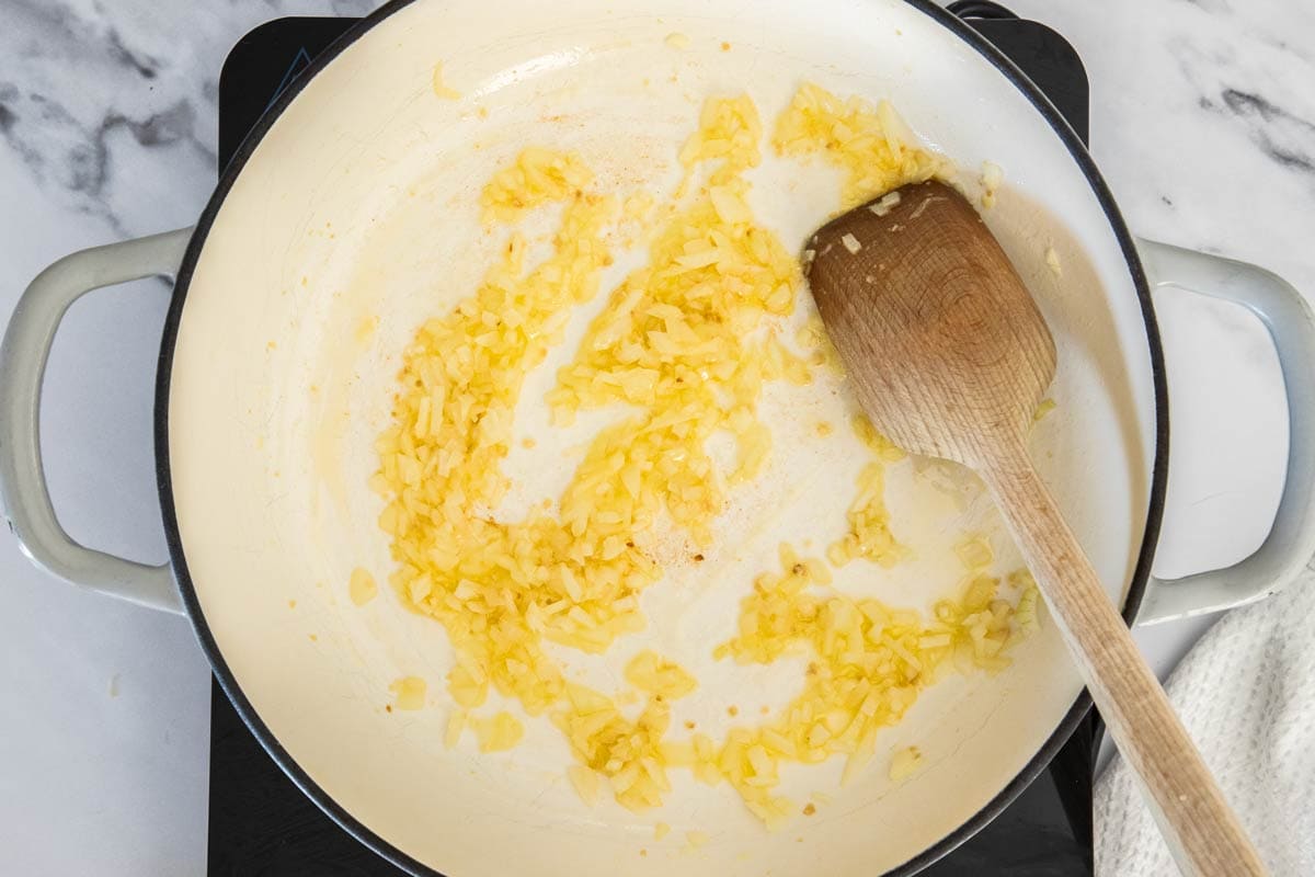 butter, garlic, and onion in a white skillet.