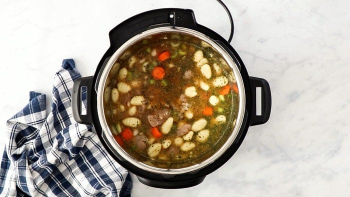 uncooked soup ingredients in a pressure cooker.